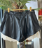 PLETED FAUX LEATHER SHORTS WITH RUFFLED LACE HEM
